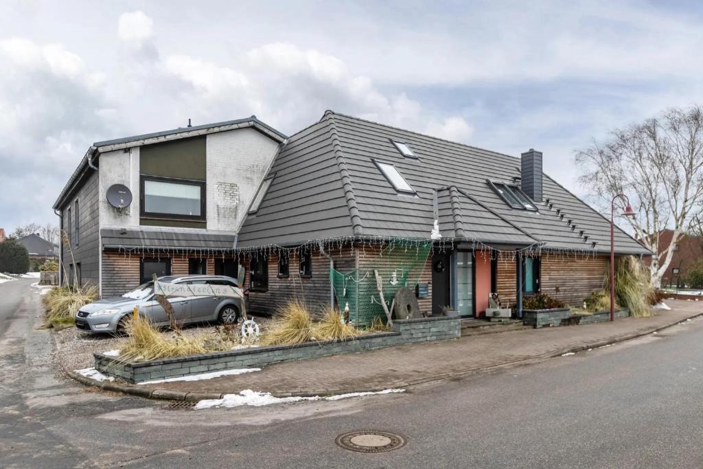 a house with a car parked in front of it at Ferienwohnung Seestern in Wester-Ohrstedt