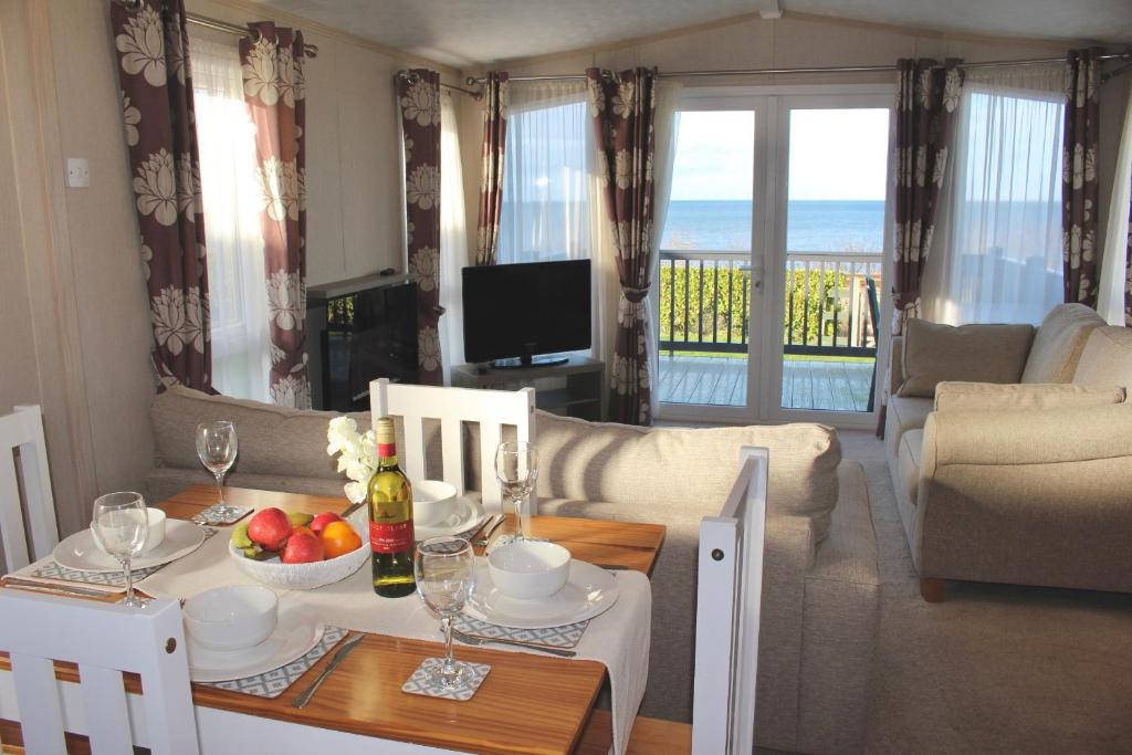 a living room with a table and chairs and a dining room at Sea View Platinum Caravan in Llanddulas