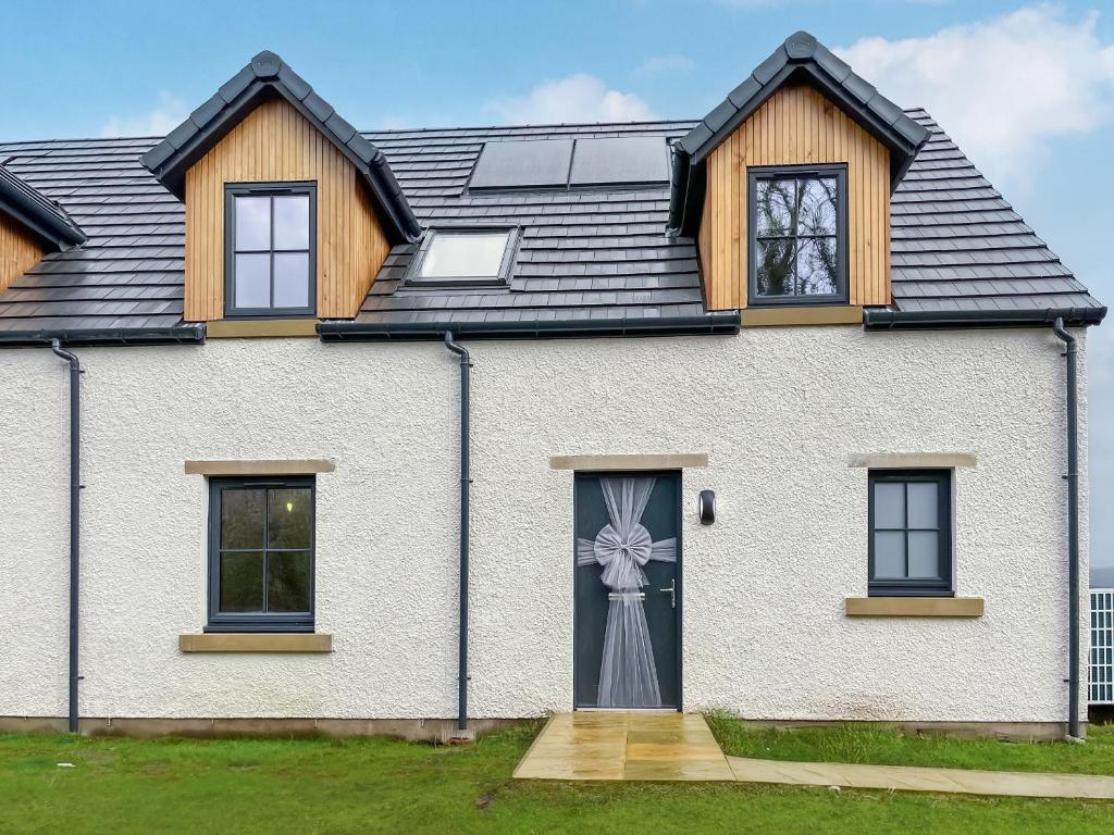 a white house with a black roof at Eriska View in Port Appin