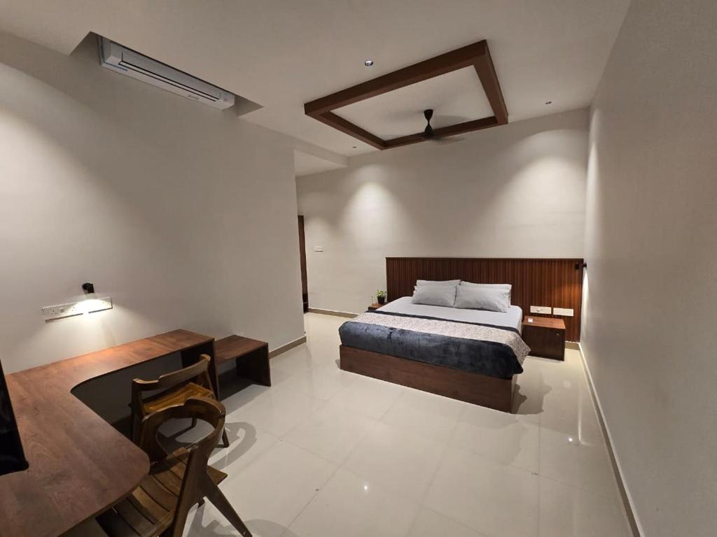 a bedroom with a bed and a desk in it at KARIPPALS INN in Kottayam