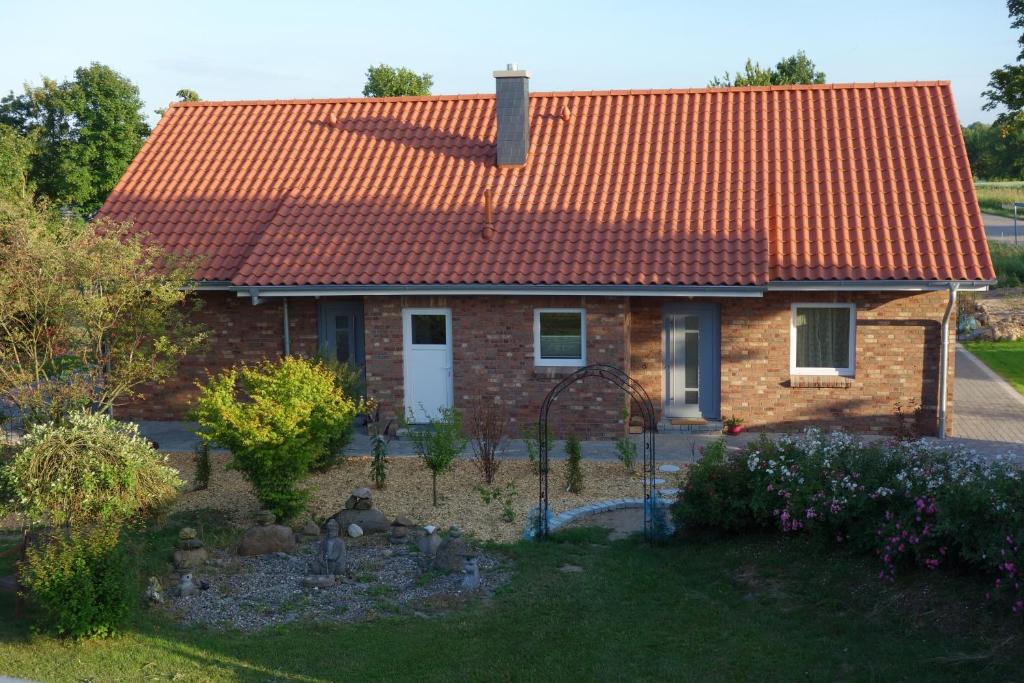 a small brick house with an orange roof at Ferienhaus Tutsch Westblick in Wangels