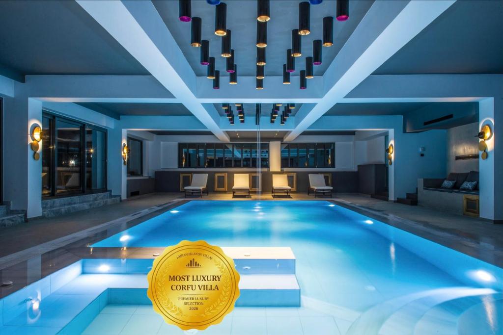 a large swimming pool with a sign in the middle at Villa Athos in Corfu