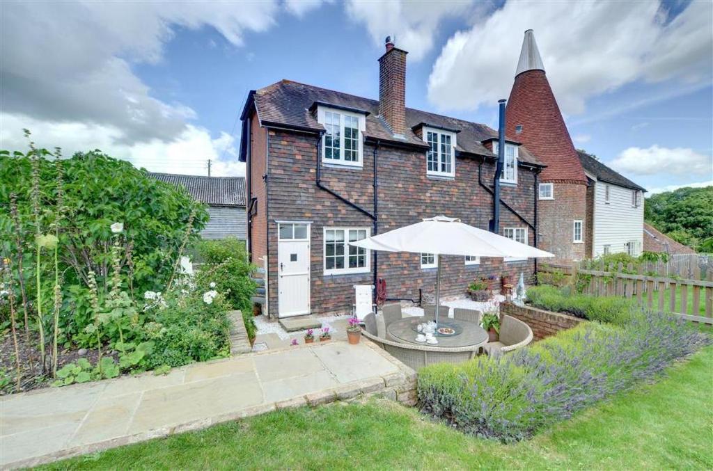 a large brick house with an umbrella in the yard at 2 Bed in Biddenden oc-cb616 in Biddenden
