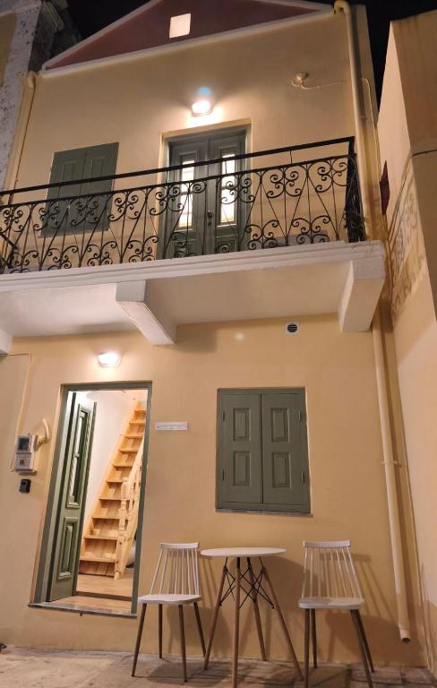 a building with a balcony and two stools at La Maisonette de Symi in Symi