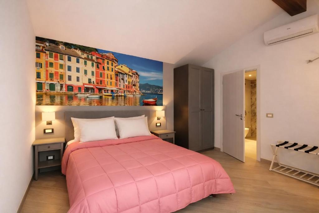a bedroom with a pink bed and a painting on the wall at Hotel Del Borgo in Sestri Levante