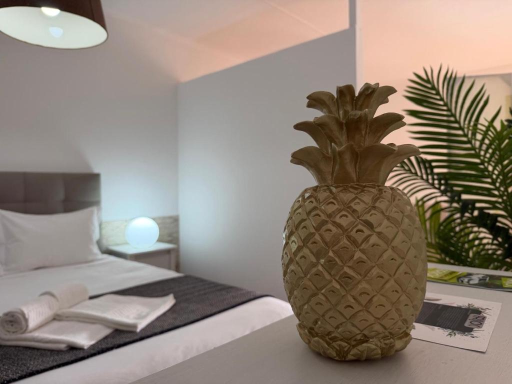 a pineapple vase sitting on a table next to a bed at Azores Pedra Apartaments A in Fajã de Baixo