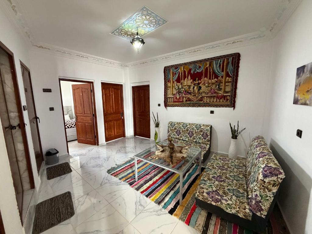 a living room with two couches and a glass table at Gaia guest house in Taghazout