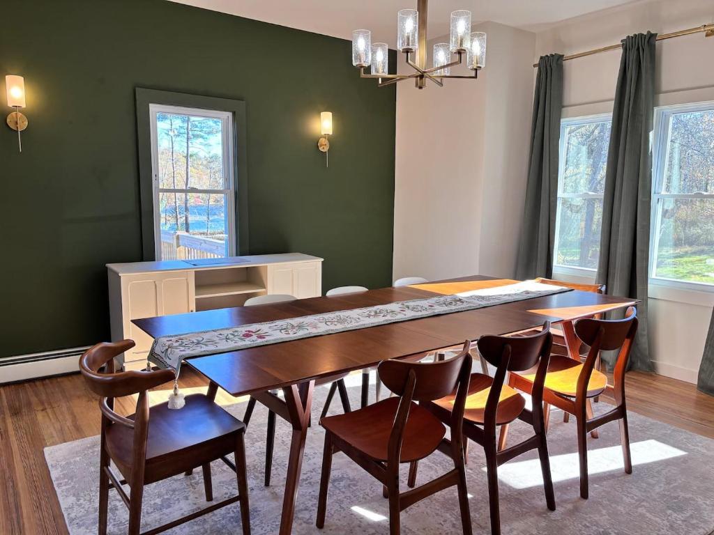 a dining room with a wooden table and chairs at Kenoza House with Private Lake and Kayaks in Callicoon