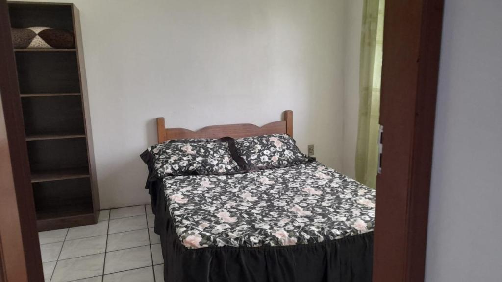 a bedroom with a bed with a black and white comforter at José Nilton in Imbituba