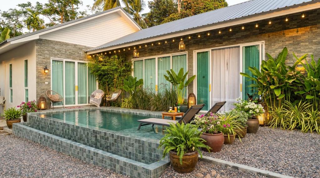 a swimming pool in front of a house at Villa Monroe - Elegant Private Pool Villa in Ban Nok