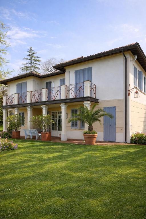 a large white house with a large yard at Atelier Monte Bago in Felegara