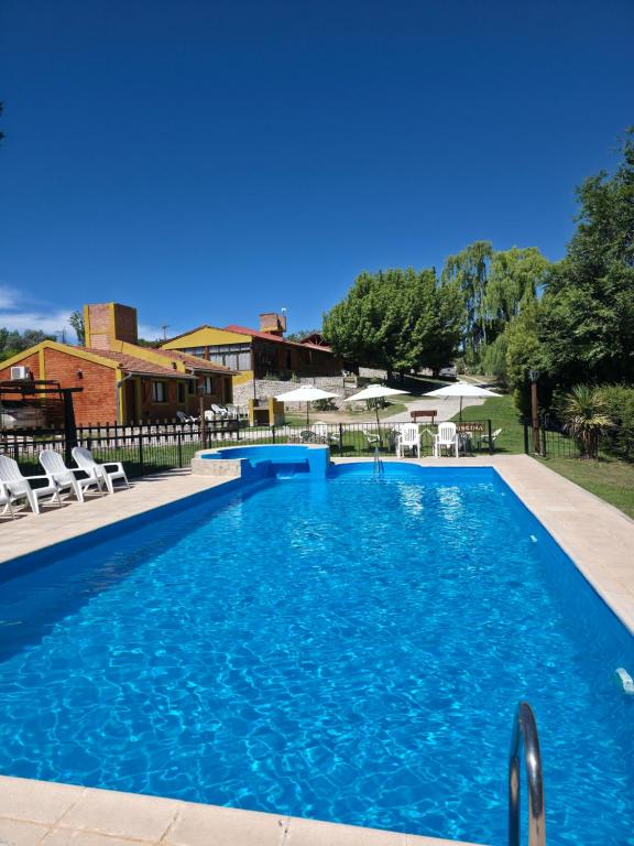 a large swimming pool with blue water in a yard at COMPLEJO DEL MIRADOR con piscina climatizada de octubre a abril in Potrero de los Funes