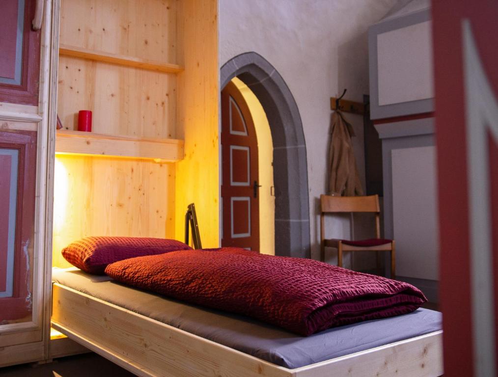 a bed with two pillows on it in a room at Herbergskirche Spangenberg - Stimmungsvolle Schlafräume, jedoch ist NUR das Badzimmer beheizt in Spangenberg