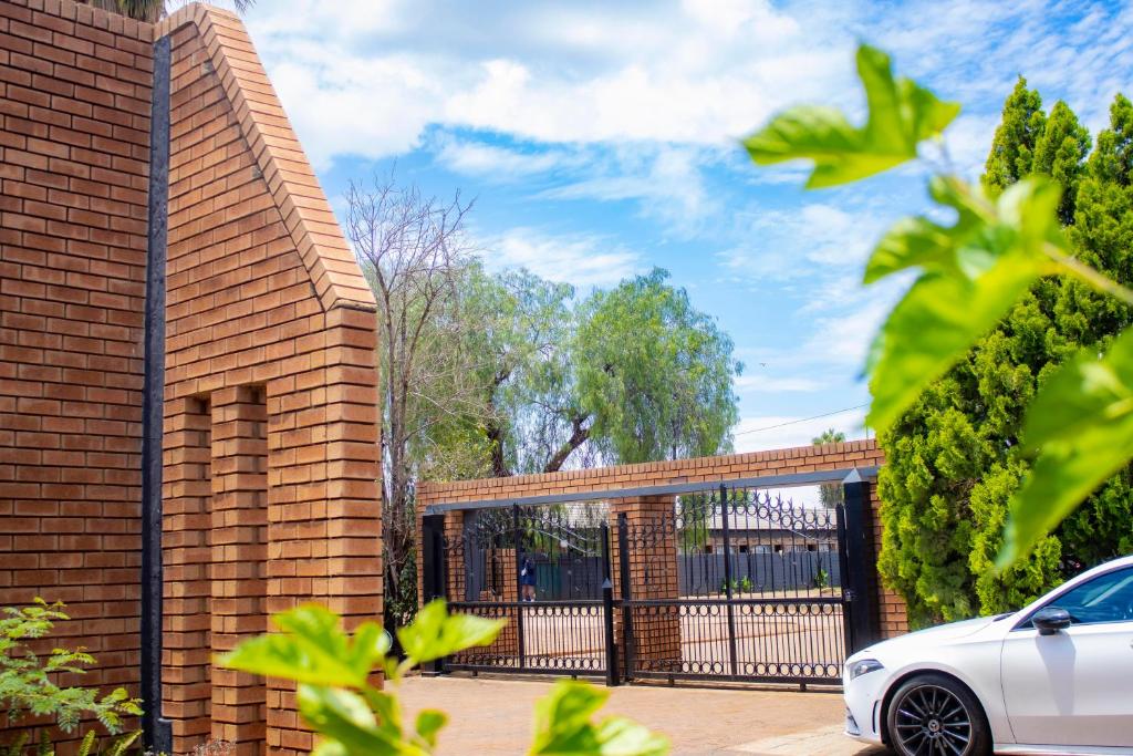 a brick house with a white car parked outside at Travel Shift Accommodation in Northam