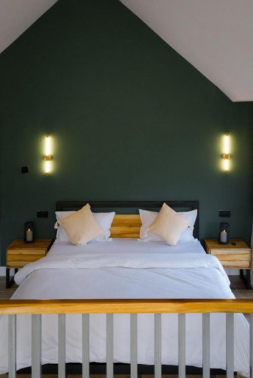 a bedroom with a large white bed with a green wall at Starico Residence in Nkoanrua