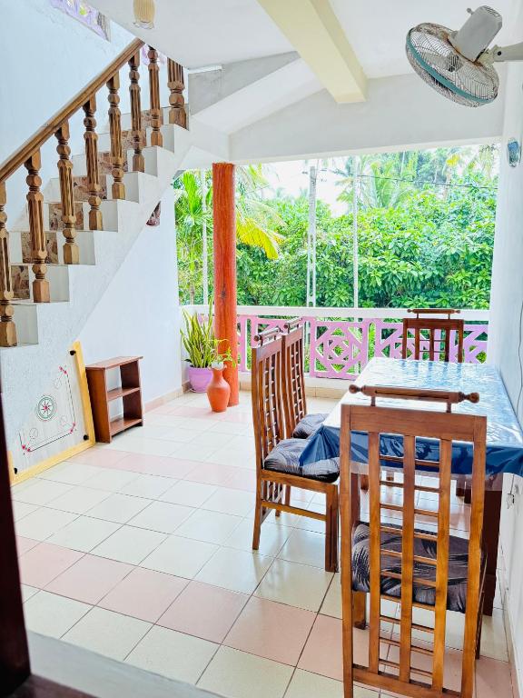 a dining room with a table and chairs and a staircase at Moragalla Relax Stay in Beruwala