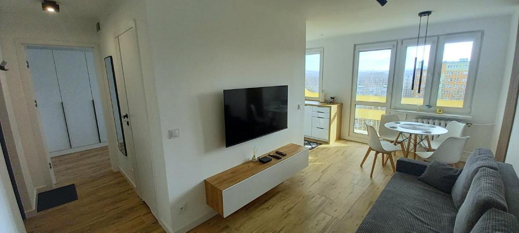 a living room with a flat screen tv on a wall at Apartament 7 Piętro in Wałbrzych