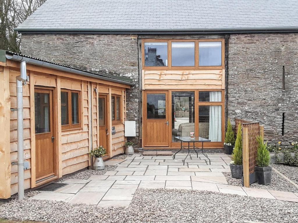 a house with wooden doors and a patio at Horsecroft - Uk37462 in Dorstone