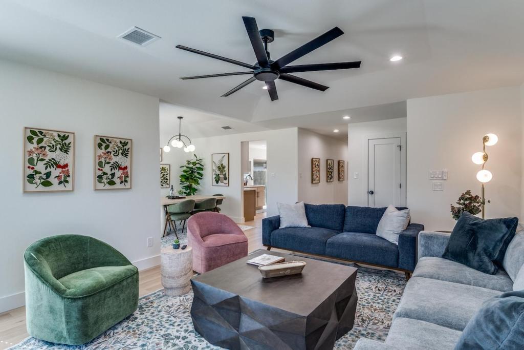 a living room with blue couches and a ceiling fan at La Fleur Chateau 4B 2B Duplex KING Pet Friendly in Richardson