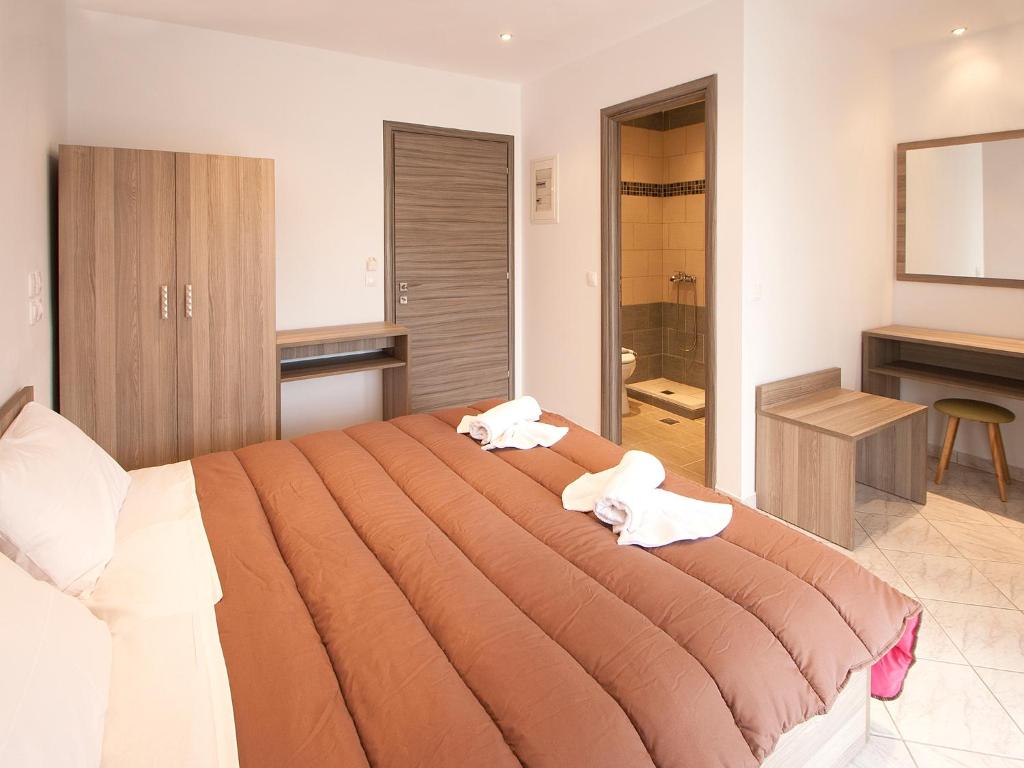1 dormitorio con 1 cama grande y 2 toallas. en PINEAPPLE Skiathos en Skiathos