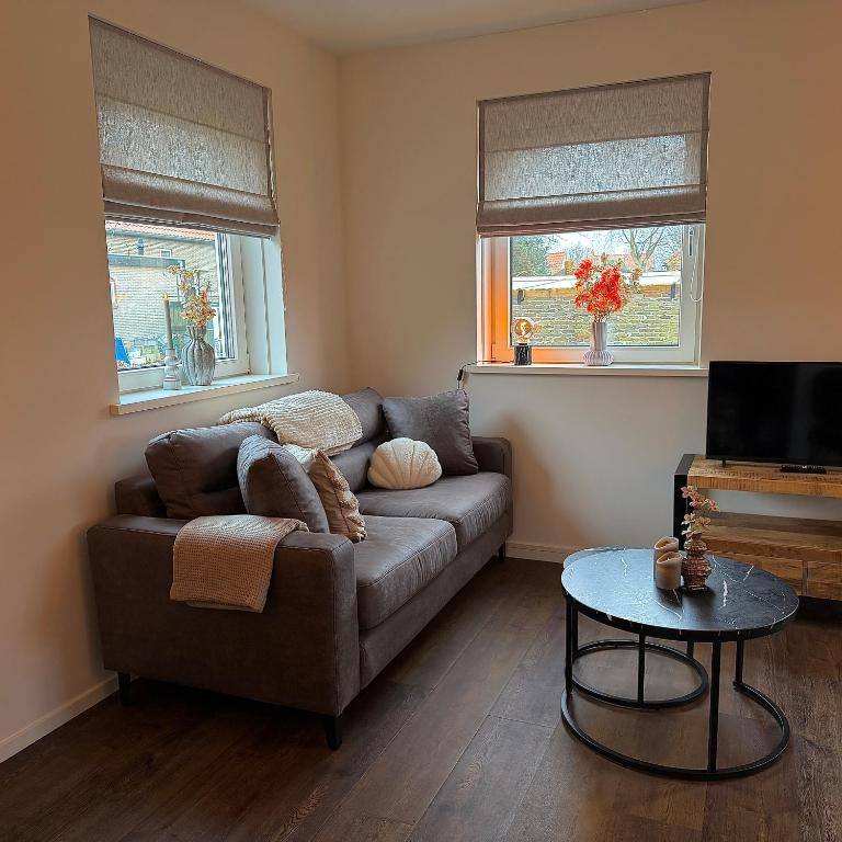 a living room with a couch and a table at Appartement Ocean Breeze Nes Ameland in Nes