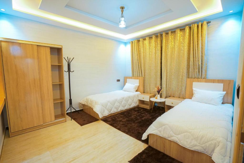 a hotel room with two beds and a window at Appartements Meublé Désert Doré Boujdour in Cabo Bojador