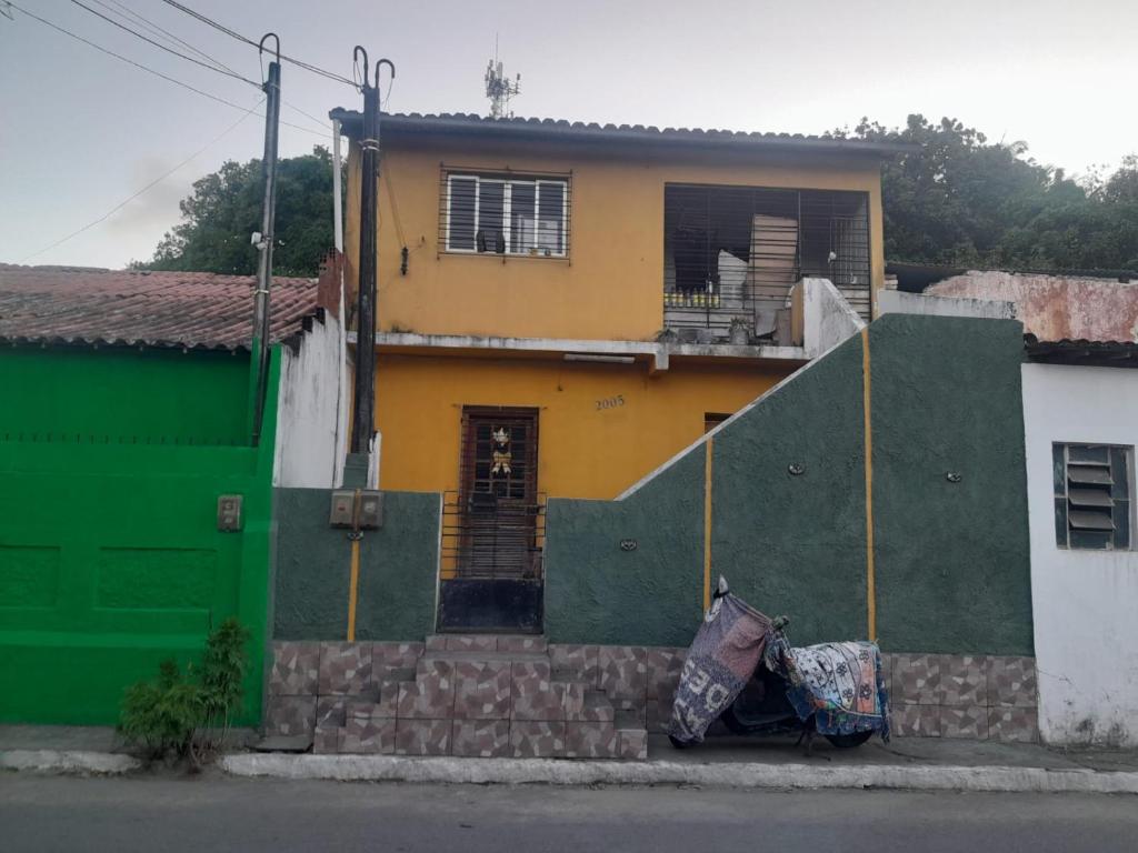 a house with a green and yellow at Quarto para carnaval Olinda e Recife in Paulista