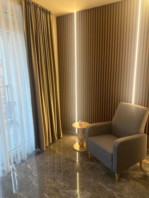 a living room with a chair and a window at Star apartmani in Novi Pazar
