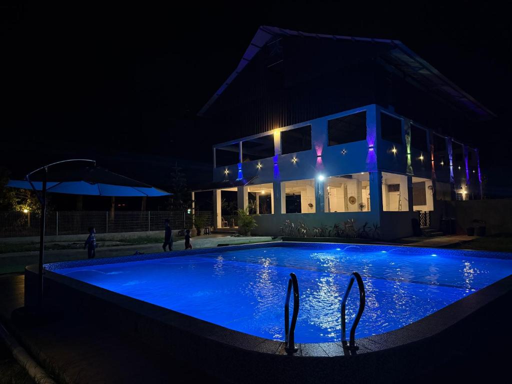 a swimming pool at night in front of a building at RTMS Guesthouse Semporna in Semporna