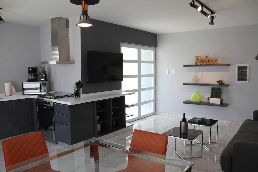 un soggiorno con cucina con tavolo in vetro di Xevize Apartment 4 a Palm Beach