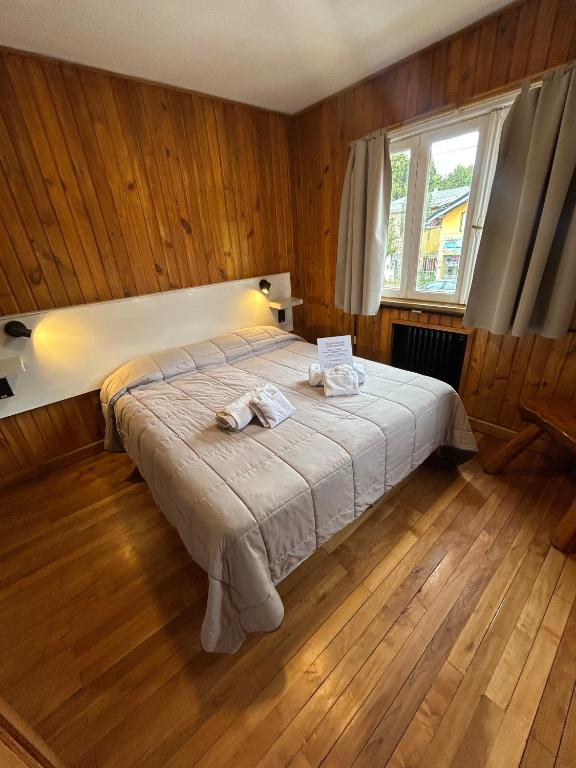 a bedroom with a bed with two towels on it at Hotel Surprise Bariloche Centro con Desayuno y Restaurante in San Carlos de Bariloche