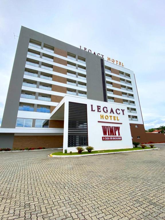 a large hotel with a sign in front of it at Legacy Hotel Guaratinguetá - Ao lado de Aparecida -SP in Guaratinguetá