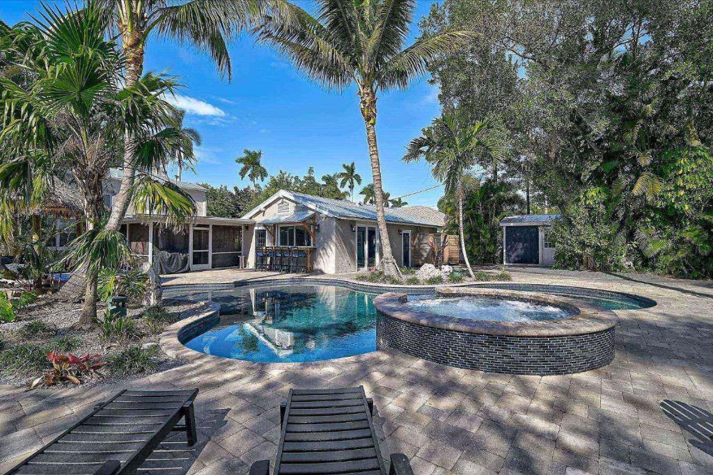 a house with a swimming pool and palm trees at Villa Manteago in Bradenton