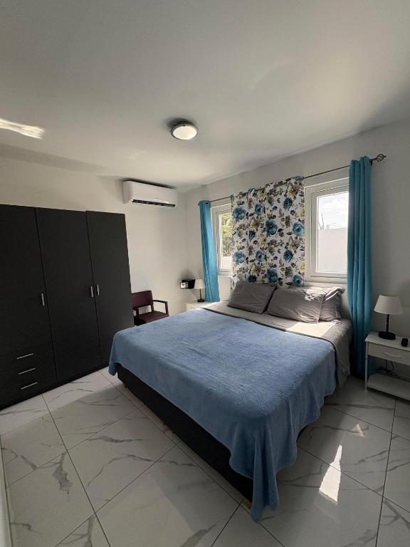 a bedroom with a large bed with a blue blanket at Viva Alto Vista! in Noord