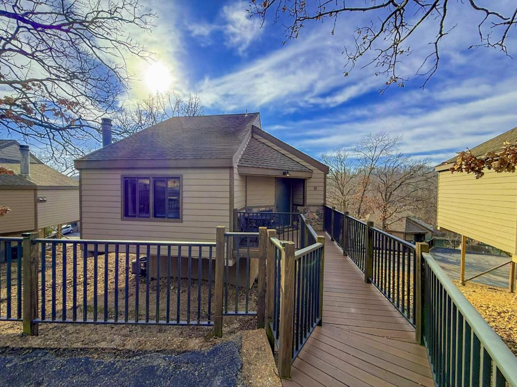 a house with a wooden deck and a fence at Sunbeam Shores 3Bed 3 Bath Pool-6PP in Osage Beach