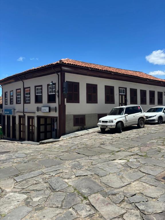 two cars parked in a parking lot in front of a building at Sollarium Pousada in Diamantina