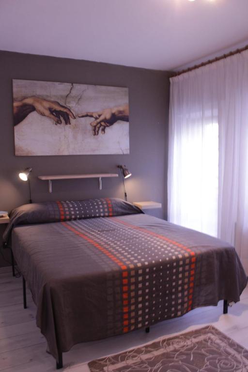 a bedroom with a bed with a painting on the wall at Levico Nature Escape in Levico Terme