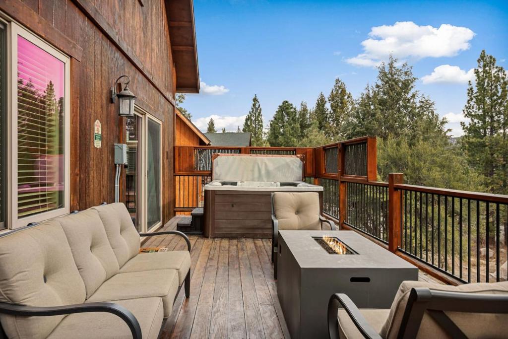 a porch with a couch and a grill on a deck at Bear Creek Lodge with Hot Tub in Big Bear Lake
