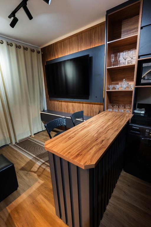 a conference room with a table and a flat screen tv at Flat exclusivo Studi Cuiabá 1605 in Cuiabá