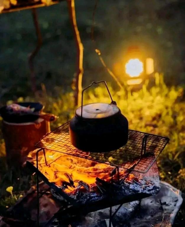 a grill with a pot on top of a fire at Pbnearswamp barbecue resort in Panama