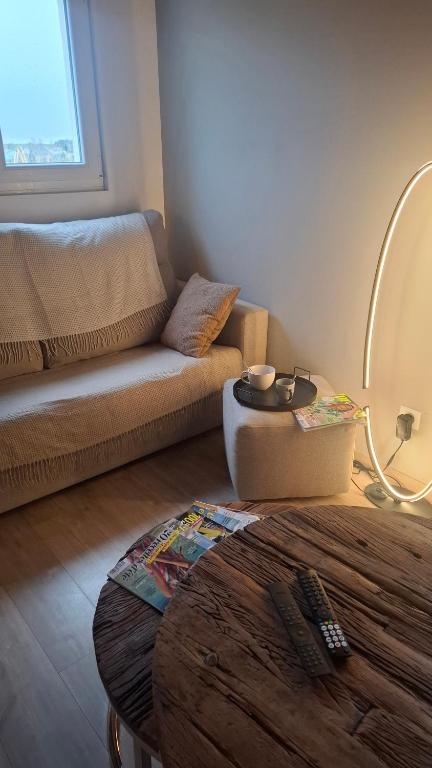 a living room with a couch and a table at Nid Douillet des Forges - Maison 2 chambres, jardin & parking gratuit in Plombières-les-Bains
