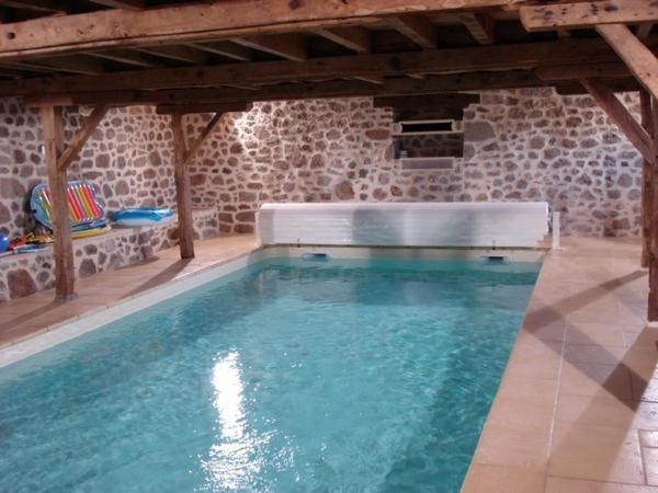 a large swimming pool in a stone building at Gite linstant rêvé in Labesserette