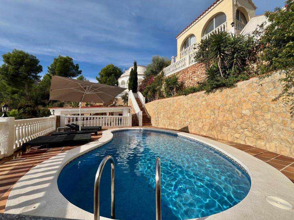 a swimming pool in front of a house at Chalet con piscina y vistas en Urb Marcolina, Alcocéber in Alcossebre