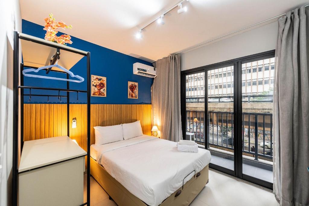 a bedroom with a bed and a large window at Studio with Pool and Gym - DP203 in São Paulo