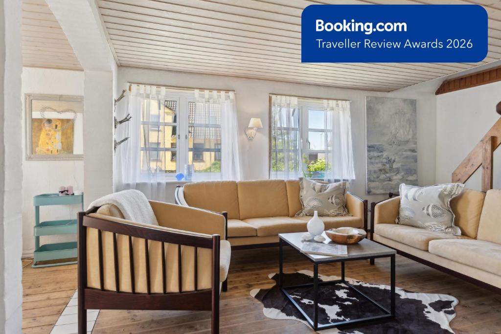 a living room with two couches and a table at The Cozy Cottage in Hirtshals