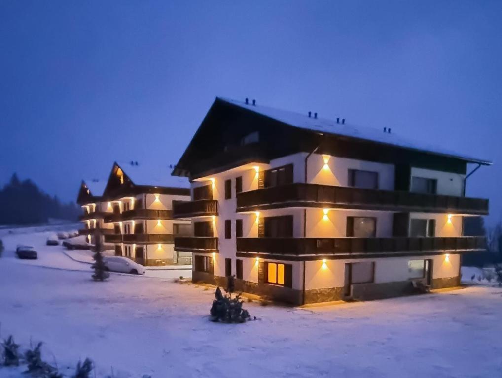 a large building in the snow at night at poiana in Sînpetru