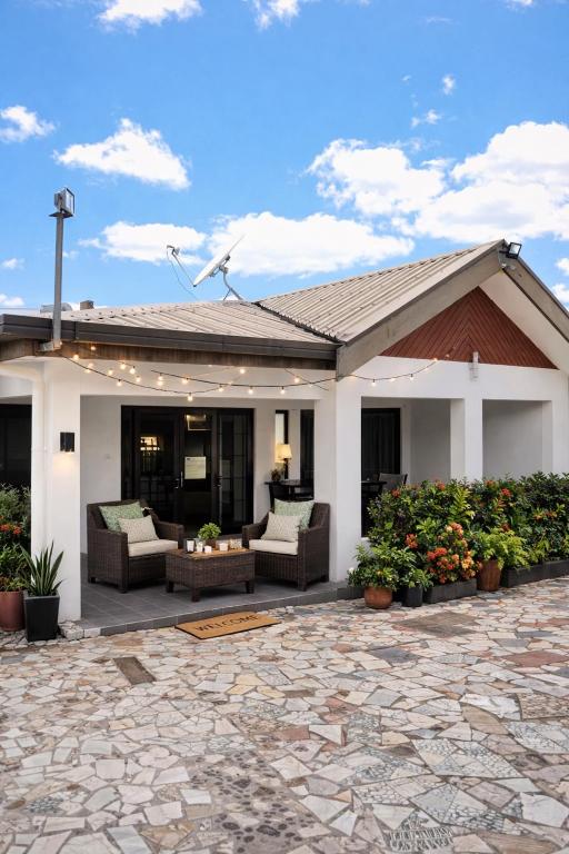 a house with a patio with couches and flowers at Nadi Airport Bed & Breakfast in Nadi