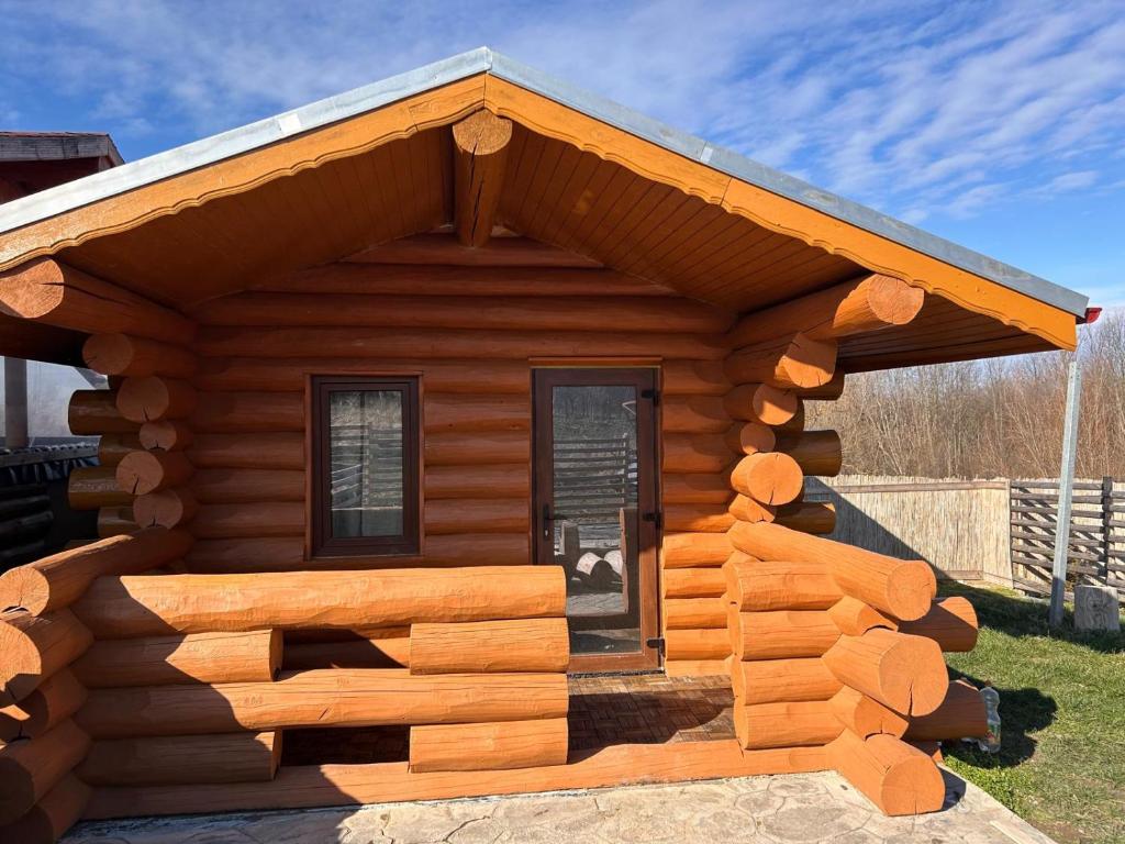 a cabin made out of logs with a roof at Casa Alexia in Potoc
