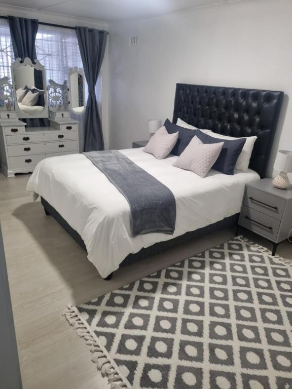 a bedroom with a large bed with a black headboard at 4 Jooste Street in Windsor Park