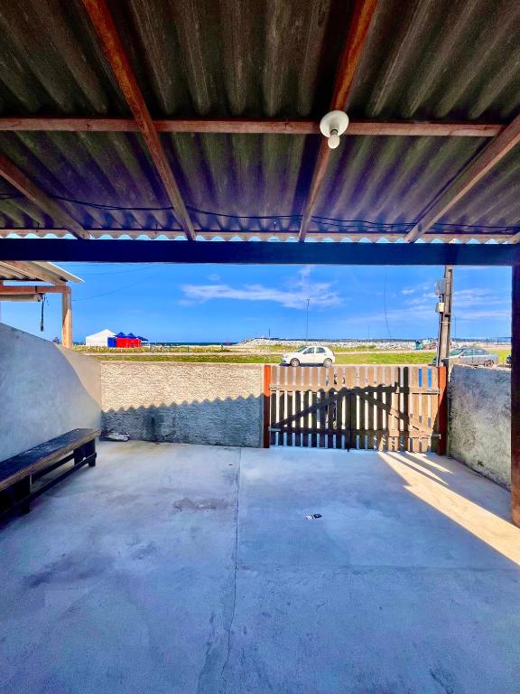 a garage with a metal roof with a view of a car at Casa Beira Mar in Matinhos